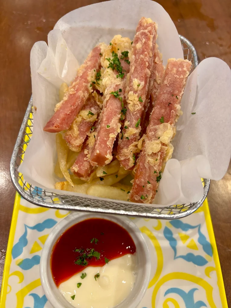 Hola Spam Fries — crispy breaded spam strips in a metal basket with ketchup and mayo dipping sauce
